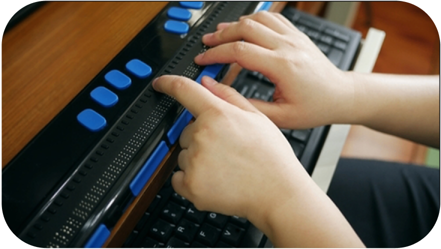 A child's hands using a brail keyboard