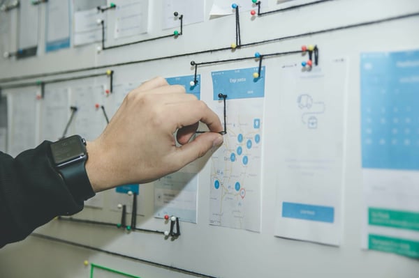 Wall of notes for project management with someone making changes