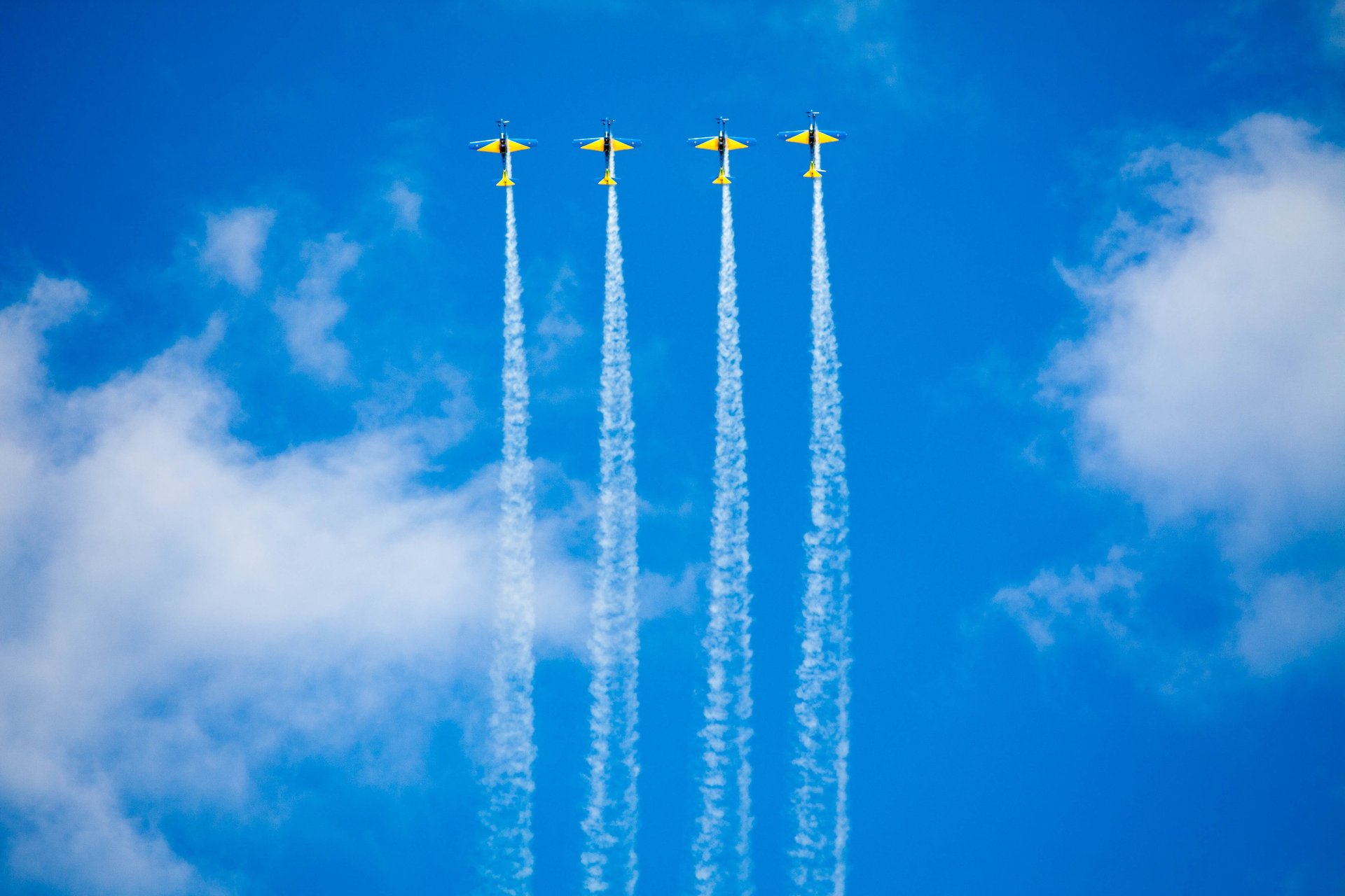Four planes flying across a blue sky to represent QA processes heading towards business goals