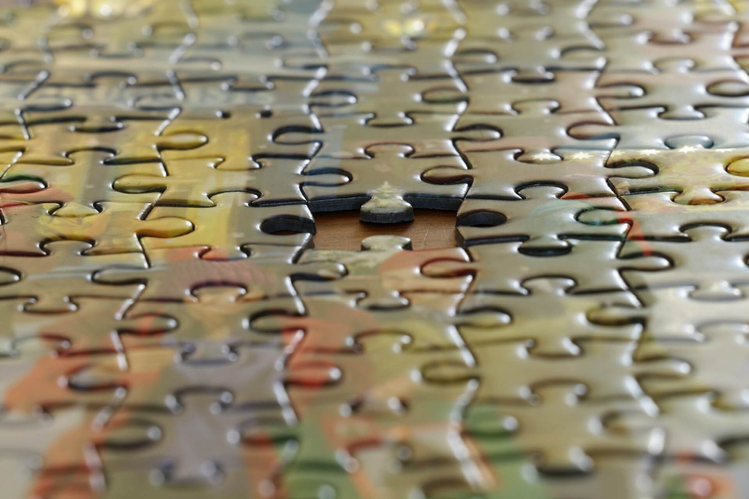Image shows a multi-colored jigsaw puzzle with a missing piece in the center
